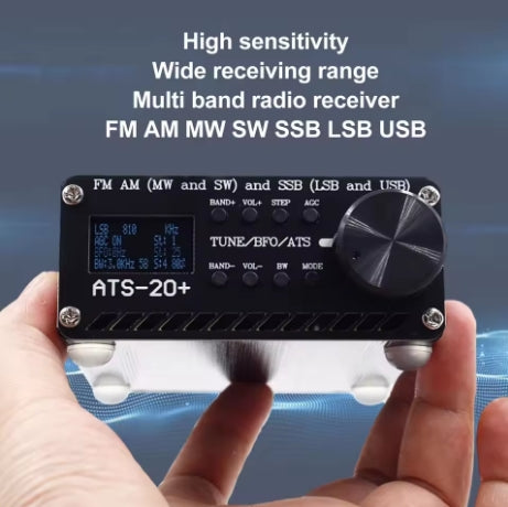 ATS-20+ Short Wave & FM Receiver All Mode including SSB being held in someones hand and showing the front screen illuminated